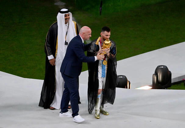 FUSSBALL WM 2022 Finale Argentinien - Frankreich 18.12.2022 Lionel Messi nimmt im Umhang (Bischt) den WM Pokal von Tamim bin Hamad Al Thani (Emir von Katar) und Fifa-Praesident Gianni Infantino entgegen