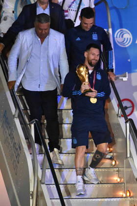 (221221) -- BUENOS AIRES, Dec. 21, 2022 -- Argentina s Lionel Messi (front) holds the FIFA World Cup, WM, Weltmeisterschaft, Fussball trophy upon arrival at Ezeiza International Airport after the team winning the Final of the 2022 FIFA World Cup in Buenos Aires, capital of Argentina, Dec. 20, 2022. (TELAM Handout via Xinhua) (SP)ARGENTINA-BUENOS AIRES-FOOTBALL-2022 WORLD CUP-TEAM ARGENTINA-ARRIVAL MeixZhoutongxunshe 