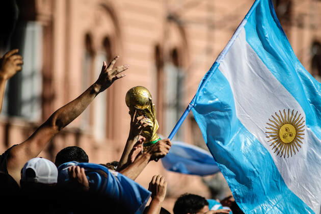 December 20, 2022, Buenos Aires, Argentina: Argentine fans display a replica of the World Cup next to the Argentine flag, during the celebrations in the Plaza de Mayo. More than 4 million people invaded the city of Buenos Aires to celebrate the world cup obtained by the Argentine Soccer Team in the FIFA World Cup, WM, Weltmeisterschaft, Fussball Qatar 2022. Buenos Aires Argentina - ZUMAs197 0197027105st Copyright: xRobertoxTuerox