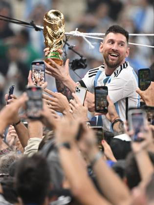 Fussball, Herren, Saison 2022 23, WM in Katar, Finale, Argentinien - Frankreich (2:2, 3:3 n. V, 4:2 i. E.) im Lusail Iconic Stadium in Lusail, Lionel Messi (Argentinien) mit Pokal, er wird lange nach Spielende im Berreich hinter dem Tor auf Schultern getragen, er wird von Fans mit dem Handy fotografiert und gefilmt, Jubel nach dem Abpfiff, 18.12. 2022, Copyright: xMatthiasxKochx
