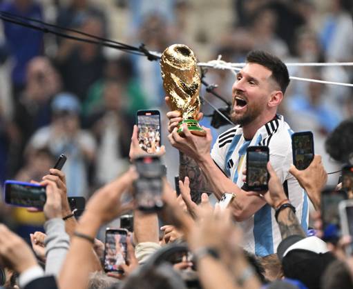 Fussball, Herren, Saison 2022 23, WM in Katar, Finale, Argentinien - Frankreich (2:2, 3:3 n. V, 4:2 i. E.) im Lusail Iconic Stadium in Lusail, Lionel Messi (Argentinien) mit Pokal, er wird lange nach Spielende im Berreich hinter dem Tor auf Schultern getragen, er wird von Fans mit dem Handy fotografiert und gefilmt, Jubel nach dem Abpfiff, 18.12. 2022, Copyright: xMatthiasxKochx