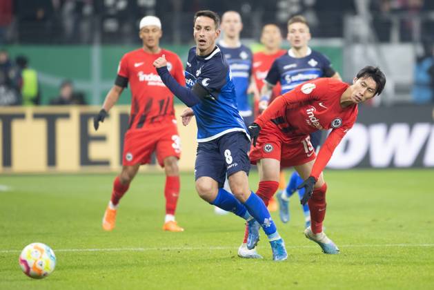 Eintracht Frankfurt - SV Darmstadt 98, DFB-Pokal Fabian Schnellhardt (Darmstadt, 8) gegen Daichi Kamada (Eintracht Frankfurt, 15). DFB-Pokalspiel zwischen Eintracht Frankfurt und dem SV Darmstadt 98 am 7. Februar 2023 im Deutsche Bank Park in Frankfurt am Main. Nach Vorgaben der DFL, Deutsche Fußball Liga, ist es untersagt, in dem Stadion und oder vom Spiel angefertigte Fotoaufnahmen in Form von Sequenzbildern und oder videoähnlichen Fotostrecken zu verwerten bzw. verwerten zu lassen., Frankfurt am Main Hessen Deutschland Deutsche Bank Park