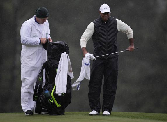 Tiger Woods dries his putter alongside caddie Joe LaCava at the 18th hole during the rain-delayed second round at the 87th Masters tournament at Augusta National Golf Club in Augusta, Georgia on Saturday, April 8, 2023. Woods finished at 147, 3 shots over par, but made the cut for the 23rd consecutive time tying Gary Player and Fred Couples.  AUG20230408214 BOBxSTRONG