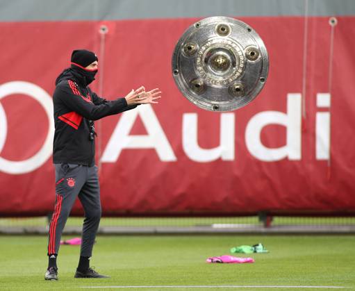 München, Deutschland 18. April 2023: Fussball, Herren, Saison 2022 2023, FC Bayern München, Säbener Strasse, Trainingsgelände, Training, Thomas Tuchel Hier eine Fotomontage, Symbolbild wie Thomas Tuchel, Trainer (FC Bayern München) die Meisterschale fängt, fangen will, dazu streckt er die Arme aus, Minimalziel