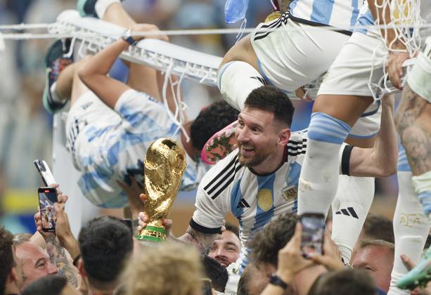 Lionel MESSI, Argentina 10 lifted on shoulders with WC trophy while Lautaro MARTINEZ, Argentina 22 Rodrigo De Paul of Argentina ad Leandro PAREDES, Argentina 5 Paulo DYBALA, Argentina 21 sit on the goal in the WC Final match ARGENTINA - FRANCE 3-3 (7-5 after penalty shoot out) FIFA World Cup, WM, Weltmeisterschaft, Fussball 2022 QATAR Season 2022 2023, Dec 18, 2022 in Lusail Stadium in Doha, Qatar.