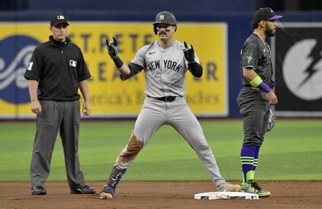 New York Yankees Austin Wells celebrates between umpire Quinn Wolcott (81) and Tampa Bay Rays José Caballero after hitting a double during the second inning of a baseball game at Tropicana Field in St. Petersburg, Florida on Saturday, May 11, 2024.  FLSN20240511107 STEVExNESIUS