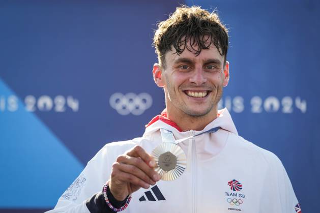 Adam Burgess of Team Great Britain smiles with his silver medal during the podium ceremony for the Men s C1 Canoe Slalom final at the Vaires-sur-Marne Nautical Stadium outside Paris during the 2024 Paris Summer Olympic Games, Olympische Spiele, Olympia, OS in Paris, France, Monday, July 29, 2024.  OLY20240729409 PaulxHanna