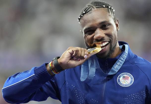 Men s 100m Final gold medalist Noah Lyles of the U.S. bites his medal on the podium at the Stade de France during the Paris 2024 Olympic Games, Olympische Spiele, Olympia, OS Athletics competition in Paris, France, on Monday, August 5, 2024.  OLY202408051673 PAULxHANNA