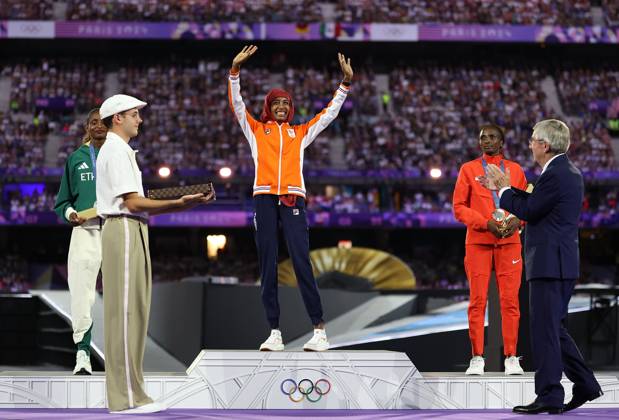 (240811) -- PARIS, Aug. 11, 2024 -- Gold medalist Sifan Hassan (C rear) of the Netherlands waves to the spectators as International Olympic Committee (IOC) President Thomas Bach (1st R) claps for her during the victory ceremony of women s marathon of Athletics at the closing ceremony of the Paris 2024 Olympic Games, Olympische Spiele, Olympia, OS in Paris, France, Aug. 11, 2024. ) (PARIS2024) FRANCE-PARIS-OLY-CLOSING CEREMONY LixMing 