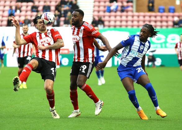 Wigan Athletic v Exeter City EFL Sky Bet League 1 28 09 2024. Exeter City defender Tristan Crama (4) Exeter City (29) and Wigan Athletic forward Silko Thomas (29) tustle for the ball during the EFL Sky Bet League 1 match between Wigan Athletic and Exeter City at the Brick Community Stadium, Wigan, England on 28 September 2024. Wigan Brick Community Stadium Greater Manchester England Editorial use only DataCo restrictions apply See www.football-dataco.com , Copyright: xJohnxBradleyx PSI-20514-0027