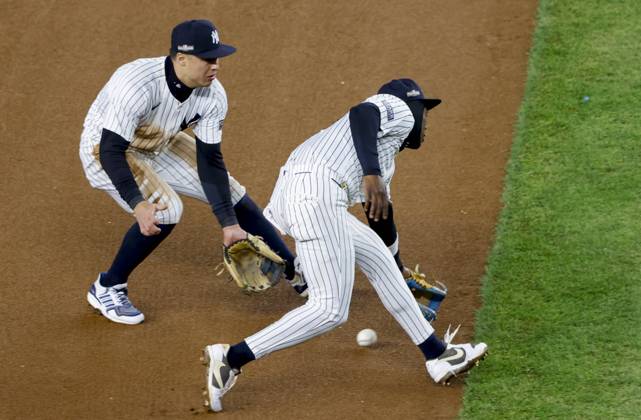 Neither New York Yankees shortstop Anthony Volpe (L) nor third baseman Jazz Chisholm Jr. can field an infield single by Cleveland Guardians Lane Thomas during the fourth inning of ALCS Game 2 at Yankee Stadium in New York, on Tuesday, October 15, 2024.  NYP20241015316 JOHNxANGELILLO
