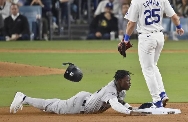 New York Yankees Jazz Chisholm Jr. loses his helmet as he steals second past Los Angeles Dodgers shortstop Tommy Edman in the sixth inning in game one of the MLB, Baseball Herren, USA World Series at Dodger Stadium on Friday, October 25, 2024.  LAP20241025820 JIMxRUYMEN