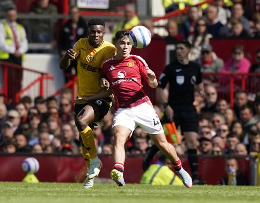 Manchester, England, 20th April 2025. Harry Amass of Manchester United, ManU (R) is challenged by Marshall Munetsi of Wolverhampton Wanderers during the Manchester United vs Wolverhampton Wanderers Premier League match at Old Trafford, Manchester. Picture credit should read: Andrew Yates Sportimage EDITORIAL USE ONLY. No use with unauthorised audio, video, data, fixture lists, club league logos or live services. Online in-match use limited to 120 images, no video emulation. No use in betting, games or single club league player publications. SPI_045_AY_MAN_UTD_WOLVES SPI-3852-0033