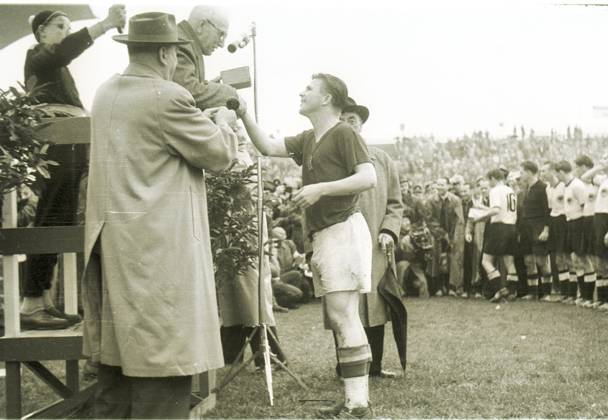 Fussballweltmeisterschaft in der Schweiz Finale Deutschland - Ungarn 3:2 (2:2) Deutschland ist Weltmeister! U.B.z. der Kapitaen des Vizeweltmeisters Ungarn, Ferenc Puskas im Gespraech mit Jules Rimet. Im Hintergrund die deutsche Mannschaft; hinter Jules Rimet steht sein Enkelsohn. 04.07.1954 in Bern (Wankdorf-Stadion) - Schweiz