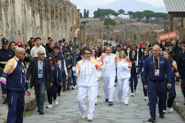 Sport Themen der Woche KW52 Pompei: December 22, 2025, Milan-Cortina 2026 Winter Olympics. The photo shows the Olympic torch passing through the Archaeological Park. Actor Jackie Chan  Copyright: xAlessandroxGarofalo LaPressex
