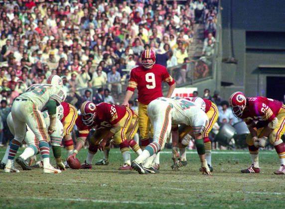 October 13, 1974, Washington, District Of Columbia, USA: Washington Redskins quarterback Sonny Jurgensen 9 calls signals as he prepares to take the snap from center Len Hauss 56 during the game against the Miami Dolphins at RFK Stadium in Washington, DC on October 13, 1974. Also pictured are Dolphins middle linebacker Nick Buoniconti 85 Dolphins right defensive end Bill Stanfill 84, and Redskins left tackle Ray Schoenke 62. The Redskins won the game 20 - 17 Washington USA - ZUMAs152 19741013_faa_s152_004 Copyright: xArniexSachsx Washington USA - ZUMA0846 19741013_faa_s152_004 Copyright: xIMAGO ArniexSachsx