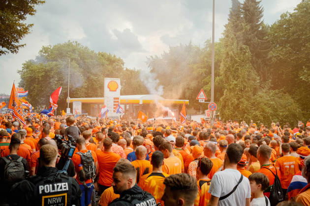 10.07.24, Football, UEFA EURO, EM, Europameisterschaft,Fussball 2024, Netherlands Fan March Police officers observe a large crowd of Netherlands supporters with flags and orange smoke near a petrol station in Dortmund, Germany, during the fan march before the UEFA Euro 2024 semi-final against England. Dortmund Dortmund NRW Germany
