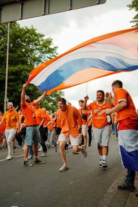 10.07.24, Football, UEFA EURO, EM, Europameisterschaft,Fussball 2024, Netherlands Fan March Dutch supporters in orange celebrate under a large orange, white and blue flag during the fan march in Dortmund, Germany, before the UEFA Euro 2024 semi-final between the Netherlands and England. Dortmund Dortmund NRW Germany