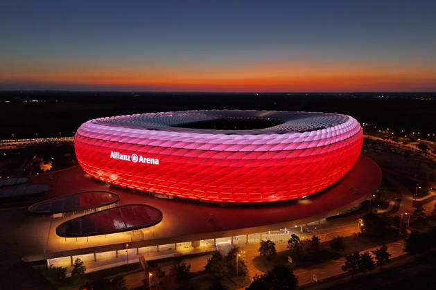 ALLIANZ ARENA leuchtet bei Nacht.Abenddaemmerung, Heimspielstaette des FC Bayern Muenchen, Fussballstadion,Stadion,Uebersicht,Totale.