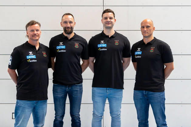 20.07.2026, xgox, Handball - Opel HBL SC Magdeburg - Fototermin Saison 2026 27 emspor, v.l. Physiotherapeut Matthias Friedrich, Steffen Mantai, Philip Zachert, Athletiktrainer Daniel Müller Magdeburg