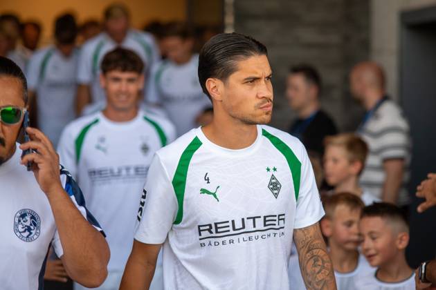 Kevin Diks ( 4; Borussia Mönchengladbach) läuft konzentriert mit dem Team auf das Spielfeld in Velbert ein. Im Hintergrund sind weitere Spieler von Borussia Mönchengladbach sowie Zuschauer und Kinder zu sehen. Kevin Diks ( 4; Borussia Mönchengladbach) beim Einlaufen in Velbert Copyright: xJonasxHunoldx
