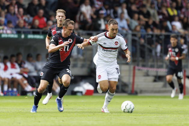KOELN, GERMANY - AUGUST 22, 2026: Julian Justvan (1. FC Nuernberg, 10) tackled by Lucas Wolf (Viktoria Koeln, 21) during the DFB-Cup match between Viktoria Koeln vs. 1. FC Nuernberg at the Sportpark Hoehenberg on August 22, 2026 in Koeln, Germany. DFL REGULATIONS PROHIBIT ANY USE OF PHOTOGRAPHS AS IMAGE SEQUENCES AND OR QUASI-VIDEO. Nordrhein-Westfalen Germany Copyright: xAxelxKohringx