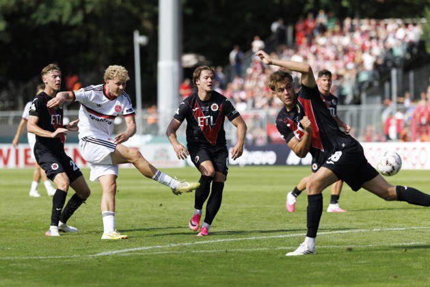 KOELN, GERMANY - AUGUST 22, 2026: Piet Scobel (1. FC Nuernberg, 19) with a shot, blocked by Tim Kloss (Viktoria Koeln, 18) during the DFB-Cup match between Viktoria Koeln vs. 1. FC Nuernberg at the Sportpark Hoehenberg on August 22, 2026 in Koeln, Germany. DFL REGULATIONS PROHIBIT ANY USE OF PHOTOGRAPHS AS IMAGE SEQUENCES AND OR QUASI-VIDEO. Nordrhein-Westfalen Germany Copyright: xAxelxKohringx