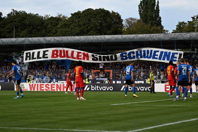 22.08.2026, xjhx, Fussball DFB Pokal 1.Runde, Eintracht Trier - RB Leipzig v.l. Spruchband, Banner Fans, Zuschauer, Ultras, Eintracht Trier Alle Bullen sind Schweine Trier