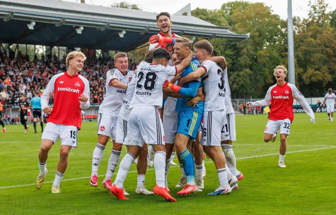 22.08.2026 - Fussball - Saison 2026 2027 - DFB Pokal Vereinspokal - 01. Runde: Viktoria Köln - 1. FC Nürnberg Nuernberg FCN ( Club ) - Sportfoto Zink DaMa - xdaxmax - regulations prohibit any use of photographs as image sequences and or quasi-video - Jubel Freude nach Spielende - Jan Reichert (1, 1. FC Nürnberg FCN ) und Mannschaft Team jubelt Jubel nach gehaltenen Elfmeter im Elfmeterschießen - nach Sieg des FCN