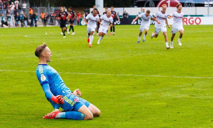 22.08.2026 - Fussball - Saison 2026 2027 - DFB Pokal Vereinspokal - 01. Runde: Viktoria Köln - 1. FC Nürnberg Nuernberg FCN ( Club ) - Sportfoto Zink DaMa - xdaxmax - regulations prohibit any use of photographs as image sequences and or quasi-video - Jubel Freude nach Spielende - Jan Reichert (1, 1. FC Nürnberg FCN ) und Mannschaft Team jubelt Jubel nach gehaltenen Elfmeter im Elfmeterschießen - nach Sieg des FCN