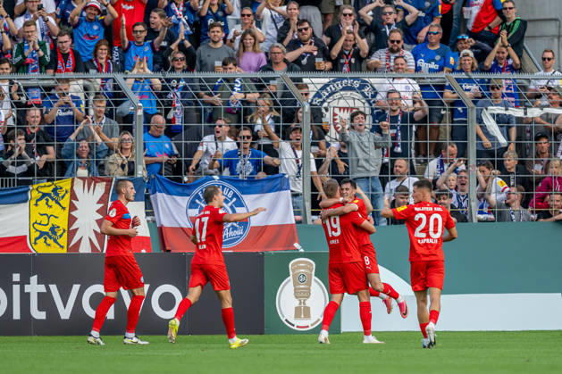Die Kieler bejubeln vor der eigenen Fankurve mit Phil Harres (Holstein Kiel, 19) dessen Tor zum 0:1 GER, TSV 1860 Muenchen vs. Holstein Kiel, Fussball, DFB-Pokal, 1. Runde, Saison 2026 2027, 22.08.2026. (DFL DFB REGULATIONS PROHIBIT ANY USE OF PHOTOGRAPHS as IMAGE SEQUENCES and or QUASI-VIDEO). Foto: HMB Media Heike Feiner Copyright: HMBxMedia HeikexFeiner