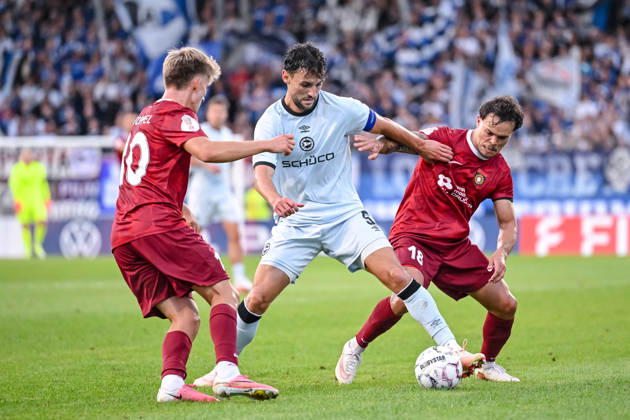 Lukas Stopel (SG Sonnenhof Grossaspach), Maximilian Bauer (Arminia Bielefeld) und Niklas Pollex (SG Sonnenhof Grossaspach) im Zweikampf waehrend des DFB-Pokal 1 Runde Spiels zwichen SG Sonnenhof Grossaspach v Arminia Bielefeld, Wir machen Druck Arena am 22. August 2026 in Grossaspach, Deutschland. (Foto von Harry Langer DeFodi Images) +++ Lukas Stopel (SG Sonnenhof Grossaspach), Maximilian Bauer (Arminia Bielefeld) und Niklas Pollex (SG Sonnenhof Grossaspach) battle for the ball during the DFB-Pokal 1 Runde match between SG Sonnenhof Grossaspach v Arminia Bielefeld at Wir machen Druck Arena on August 22, 2026 in Grossaspach, Germany. (Photo by Harry Langer DeFodi Images) (Photo by Harry Langer DeFodi Images) DFB DFL REGULATIONS PROHIBIT ANY USE OF PHOTOGRAPHS AS IMAGE SEQUENCES AND OR QUASI-VIDEO. -