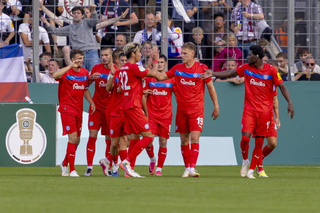 München, Deutschland 22. August 2026: DFB-Pokal - 2026 2027 - 1. Runde - TSV 1860 München gegen Holstein Kiel Im Bild: in der Traube Torschütze Phil Harres(Kiel) jubelt nach seinem Tor zum 0:1 mit seinen Mannschaftskollegen, DFB DFL regulations prohibit any use of photographs as image sequences and or quasi-video Grünwalder Stadion Bayern Copyright: xFotostandx xSchäferx