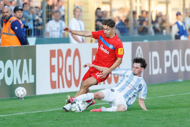 Moritz Reimers (22, Holstein Kiel) und Lance Fiedler (47, TSV 1860 München) beim Spiel zwischen TSV 1860 München v Holstein Kiel, Fussball, Herren, Dfb Pokal, 2026 2027, 1.Runde am 22.08.2026 in München, Städtisches Stadion an der Grünwalder Straße. Bayern Deutschland
