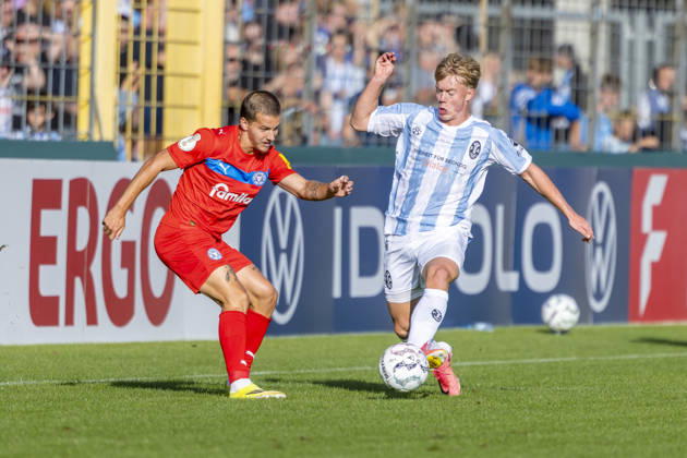 München, Deutschland 22. August 2026: DFB-Pokal - 2026 2027 - 1. Runde - TSV 1860 München gegen Holstein Kiel Im Bild: v. li. im Zweikampf John Tolkin (Kiel) und Fabio Wagner (TSV) DFB DFL regulations prohibit any use of photographs as image sequences and or quasi-video Grünwalder Stadion Bayern Copyright: xFotostandx xSchäferx