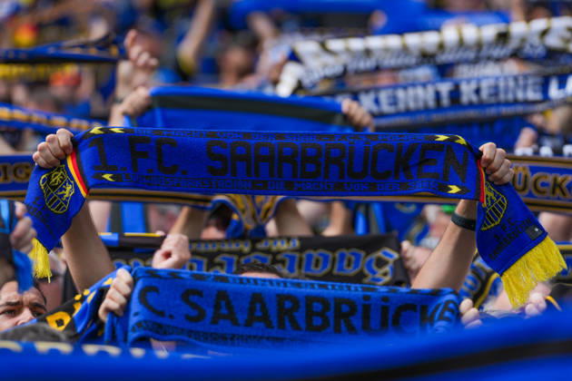 22.08.2026, xydrx, Fußball, DFB Pokal, 1. FC Saarbrücken - Hertha BSC, Saison 2026 2027, Ludwigsparkstadion: Ein Fan des 1.FC Saarbruecken hält einen Schal hoch DFB regulations prohibit any use of photographs as image sequences and or quasi-video. Copyright: HMBxMedia YannisxDreimann