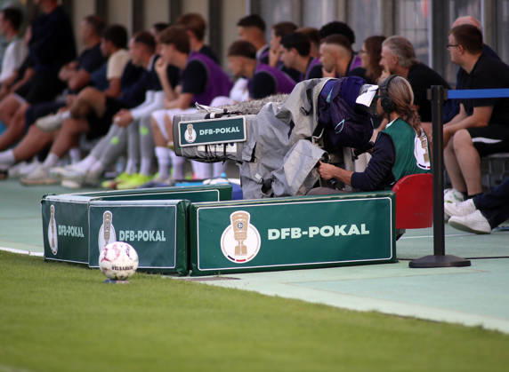 Fussball, Herren, DFB-Pokal, 1.Hauptrunde, Saison 2026 2027, TSV 1860 München - Holstein Kiel, Grünwalder Stadion Hier eine TV Kamera mit Banden drumherum und dem Schritzug und Logo DFB-Pokal, Live, Übertragung, Fernsehen