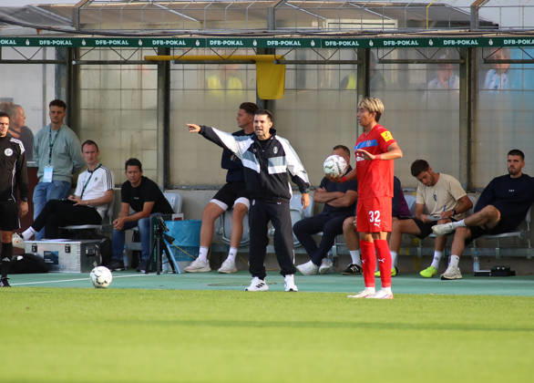 Fussball, Herren, DFB-Pokal, 1.Hauptrunde, Saison 2026 2027, TSV 1860 München - Holstein Kiel, Grünwalder Stadion Alper Kayabunar, Trainer (TSV 1860 München) hebt den rechten Arm, an der Seitenlinie stehend