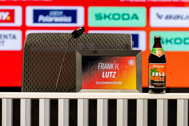 Der Platz fuer Frank Lutz (Vorstandsvorsitzender, Deutscher Eishockey Bund DEB) mit Bezeichnung und Sponsoren - Trinkflasche ist bereit GER, Eishockey, Pressekonferenz, offizielle Vorstellung neuer Bundestrainer Deutscher Eishockey Bund DEB, 27.08.2026 Foto: HMB Media Franz Feiner Copyright: HMBxMedia FranzxFeiner