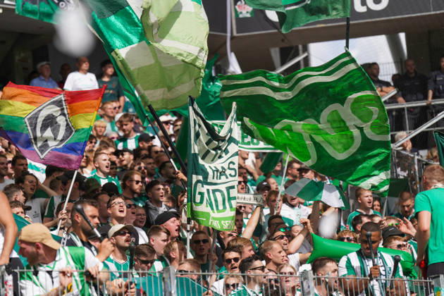 Deutschland: Fussball Bundesliga Saison 2026 - 2027, 1. Spieltag - SC Freiburg vs Werder Bremen - Europa Park Stadion (Freiburg): Fußballfans von Werder Bremen auf der Tribüne im Stadion, dicht gefüllte Fankurve mit zahlreichen grün-weißen Fahnen und Vereinsfarben. Im Vordergrund große Schwenkfahnen, darunter eine Regenbogenfahne mit Werder-Raute. Zuschauer, Fans, Supporter, Fankultur, Fanblock, Tribüne, Fahnenmeer, Regenbogen, Pride, Vielfalt, LGBTQ, Stimmung, Emotionen, Fan-Support, Werder Bremen. Copyright: xJOERANxSTEINSIEKx