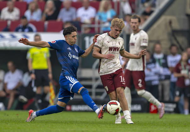 30.08.2026, Fussball Bundesliga 2026 2027, 1.Spieltag, FC Augsburg - FC Schalke 04, in der WWK-Arena Augsburg, v.li: Soufiane El-Faouzi (FC Schalke 04) gegen Hennes Behrens (FC Augsburg)