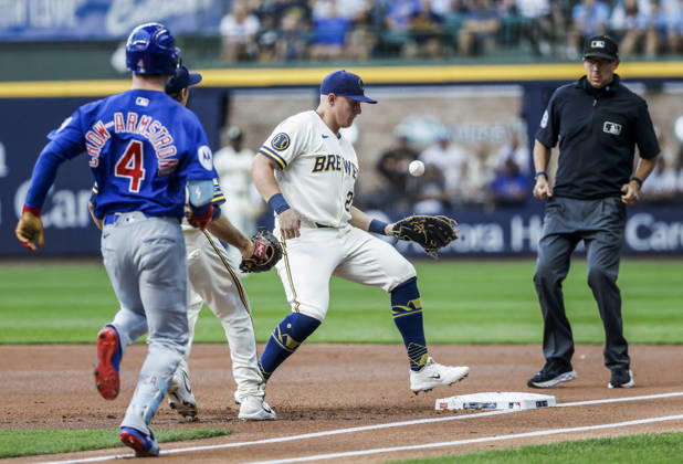 First base umpire Adam Hamari (R) watches as Milwaukee Brewers first baseman Andrew Vaughn (C) bobbles a ground ball hit by Chicago Cubs center fielder Pete Crow-Armstrong (L) before stepping on the base in the first inning of the MLB, Baseball Herren, USA game between the Chicago Cubs and the Milwaukee Brewers at American Family Field in Milwaukee, Wisconsin on Monday, September 7, 2026.  MIL20260907803 TANNENxMAURY