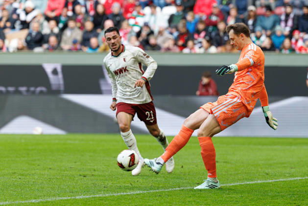 Manuel Neuer (1, FC Bayern München) im Hintergrund, Arijon Ibrahimovic (21, FC Augsburg) beim Spiel zwischen FC Augsburg v FC Bayern München, Fussball, Herren, Bundesliga, 2026 2027, 5.Spieltag am 10.10.2026 in Augsburg, WWK ARENA. DFL and DFB regulations prohibit any use of photographs as image sequences and or quasi-video. Bayern Deutschland