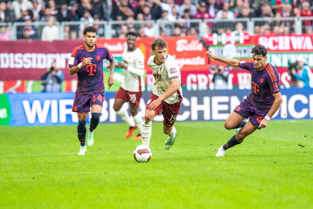 Robin Fellhauer (19 Augsburg) und Aleksandar Pavlovic (45 Bayern) in Aktion beim Bundesligaspiel FC Augsburg - FC Bayern München am 10.10.2026.