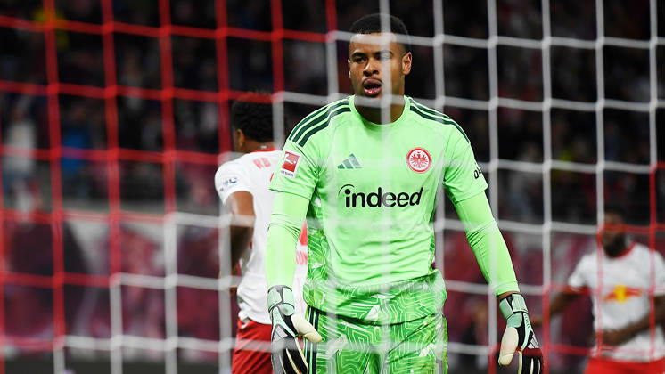 Fußball Bundesliga, Saison 2026 2027, 5. Spieltag, RB Leipzig vs. SGE Eintracht Frankfurt (10.10.2026) Noah Atubolu (Torwart Frankfurt, Rückennummer 1) ärgert sich nach dem 4:0 von Torschütze Christopher Nkunku (Mittelstürmer RB Leipzig, Rückennummer 28) (hinten) beim Bundesliga-Spiel Leipzig gegen Eintracht Frankfurt (10.10.2026). Leipzig Sachsen Deutschland Red-Bull Arena