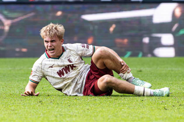 Deutschland: FC Augsburg vs FC Bayern München, 1. Bundesliga, 5. Spieltag, Saison 2026 27, WWK Arena (Augsburg): Hennes Behrens, (FC Augsburg, 16) liegt mit Schmerzen am Boden Augsburg WWK Arena Bayern Deutschland Copyright: xBenedictxChristx