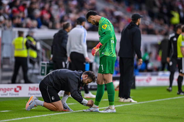 11.10.2026, Fussball, Saison 2026 2027, Bundesliga, SC Freiburg - FC Schalke 04, Mio Backhaus (SC Freiburg) bekommt die Schuhe gebunden, xRHR-FOTO YYx Copyright: KROEGER RHR-FOTOx RHR-FOTO YY