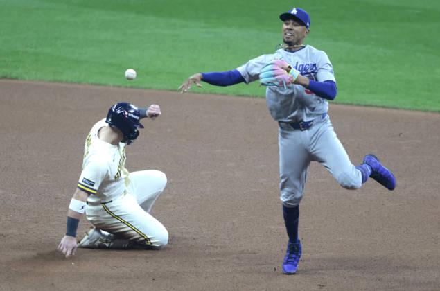 Los Angeles Dodgers shortstop Mookie Betts (50) turns a double play as Milwaukee Brewers Jake Bauers (9) slides into second in the fourth inning of an MLB, Baseball Herren, USA National League Championship Series playoff game at American Family Field in Milwaukee, Wisconsin, on Sunday, October 11, 2026.  MIL20261011715 TANNENxMAURY