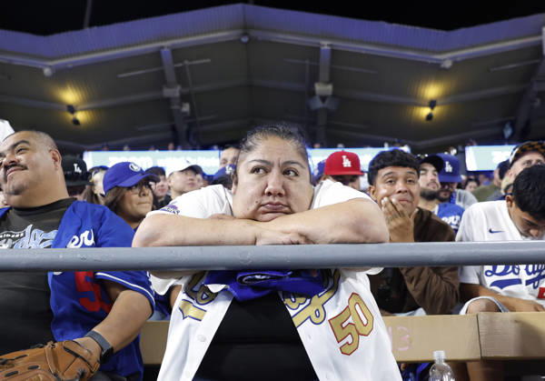 A Los Angeles Dodgers fan watches the action as the Dodgers trail the Milwaukee Brewers 5-2 in the bottom of the eighth inning in the MLB, Baseball Herren, USA National League Championship Series playoffs at Dodger Stadium in Los Angeles, California, on Wednesday, October 14, 2026.  LAP20261014737 CAROLINExBREHMAN
