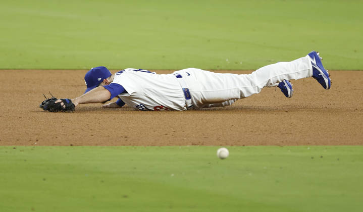 Los Angeles Dodgers third baseman Max Muncy (13) dives for a sharp grounder by Milwaukee Brewers Joey Ortiz in the ninth inning in the MLB, Baseball Herren, USA National League Championship Series playoffs at Dodger Stadium in Los Angeles, California, on Wednesday, October 14, 2026.  LAP20261014744 CAROLINExBREHMAN